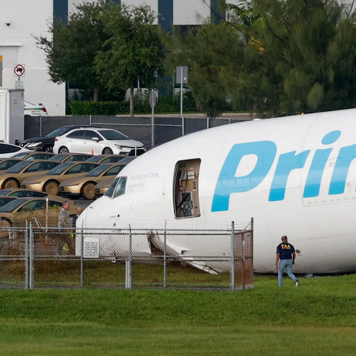 A view of an Amazon Prime Air cargo plane that airport officials said overran a runway at Miami International Airport, next to rows of Tesla Cybercabs, in Miami, Florida, U.S., September 6, 2026. REUTERS/Marco Bello