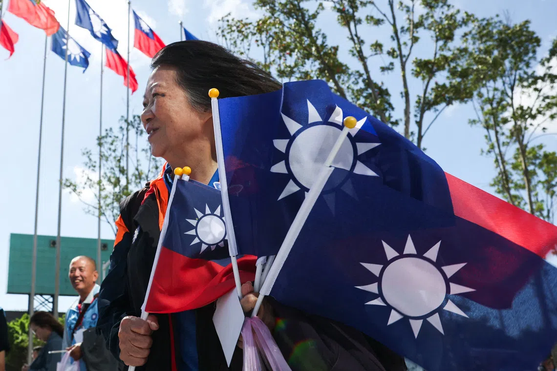 A woman holds flags amid celebrations of the 130th foundation anniversary of Taiwan's largest opposition party Kuomintang (KMT), in Taoyuan, Taiwan November 24, 2024. REUTERS/Ann Wang