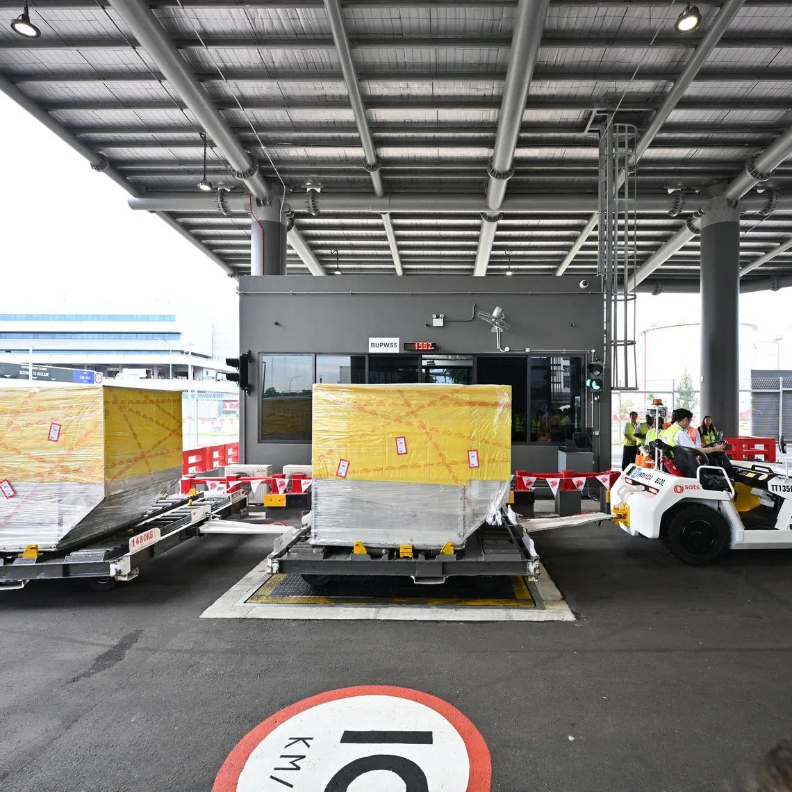 [Embargoed till 5:30PM on 5 August 2025.]

ST20250805-202554700339-Lim Yaohui-Esther Loi-essats05/

Tractor pulling a dolly with cargo during the official opening of the BUP Handling Centre by representatives from Singapore’s aviation ecosystem, including SIA, CAAS, Changi Airport group, major freight forwarders in a joint show of support on Aug 5, 2025. 

The BUP Handling Centre is named after BUPs, or Bulk Unitisation Programme shipments, which are cargo packages assembled by freight forwarders or shippers and delivered to SATS to be loaded onto flights. It covers an area about half the size of a soccer field at SATS Cargo's Airfreight Terminal. This dedicated and sheltered facility resembles the clearance lanes for cargo trucks at Singapore's Tuas and Woodlands checkpoints.

(ST PHOTO: LIM YAOHUI)