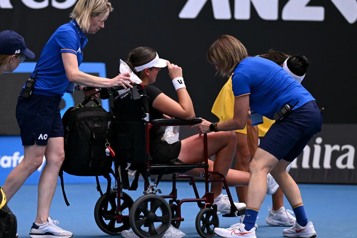 Tennis - Australian Open - Melbourne Park, Melbourne, Australia - January 19, 2026 Canada's Marina Stakusic is assisted onto a wheelchair after retiring from her first round match against Australia's Priscilla Hon REUTERS/Jaimi Joy