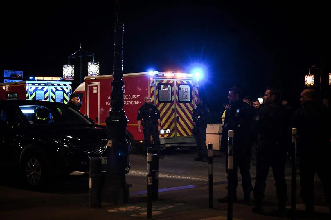 Police officers stand in a street after a man stabbed and killed one person and injured another.