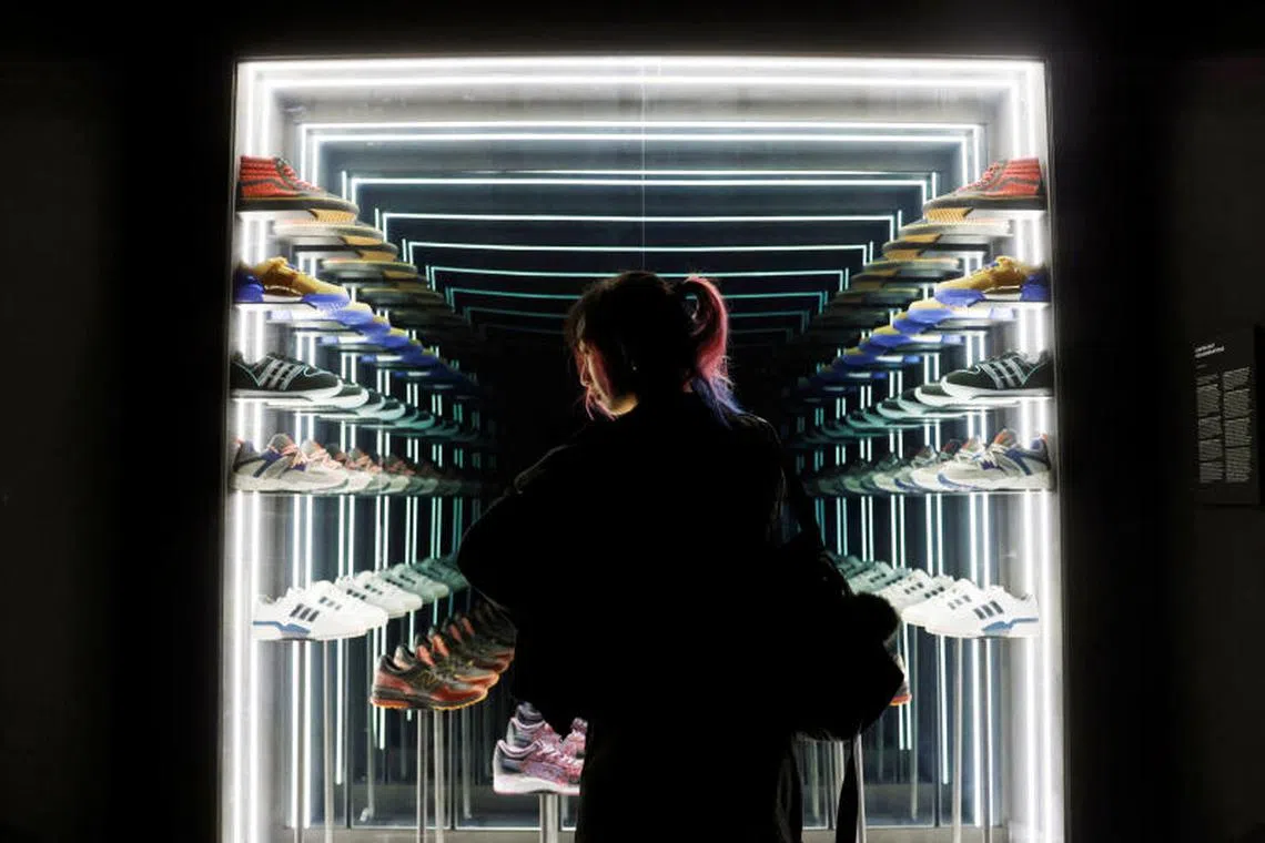 A visitor looks at a display of limited edition sneakers of various brands made in collaboration with local sneaker shop Limited Edt, during the media preview of Sneakertopia, a sneaker and street culture exhibition, at the Art Science Museum in Singapore on February 23, 2023. PHOTO : REUTERS