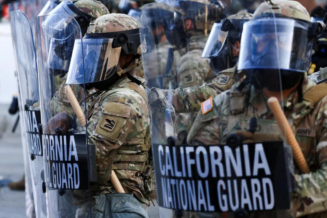 FILE PHOTO: National Guard troops wear gas masks during protests against federal immigration sweeps, in Los Angeles, California, U.S., June 12, 2025. REUTERS/David Swanson/File Photo