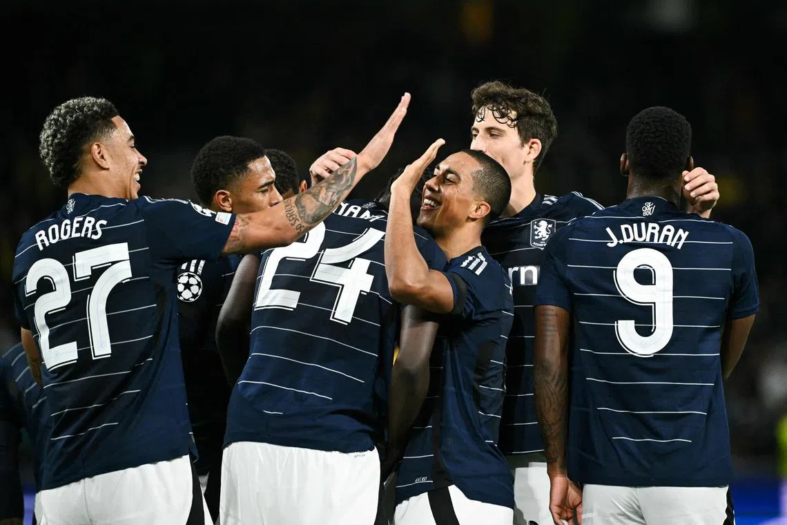 Aston Villa's Amadou Onana (centre) celebrates with fellow midfielder Youri Tielemans (centre, right) and teammates after scoring his team's third goal.