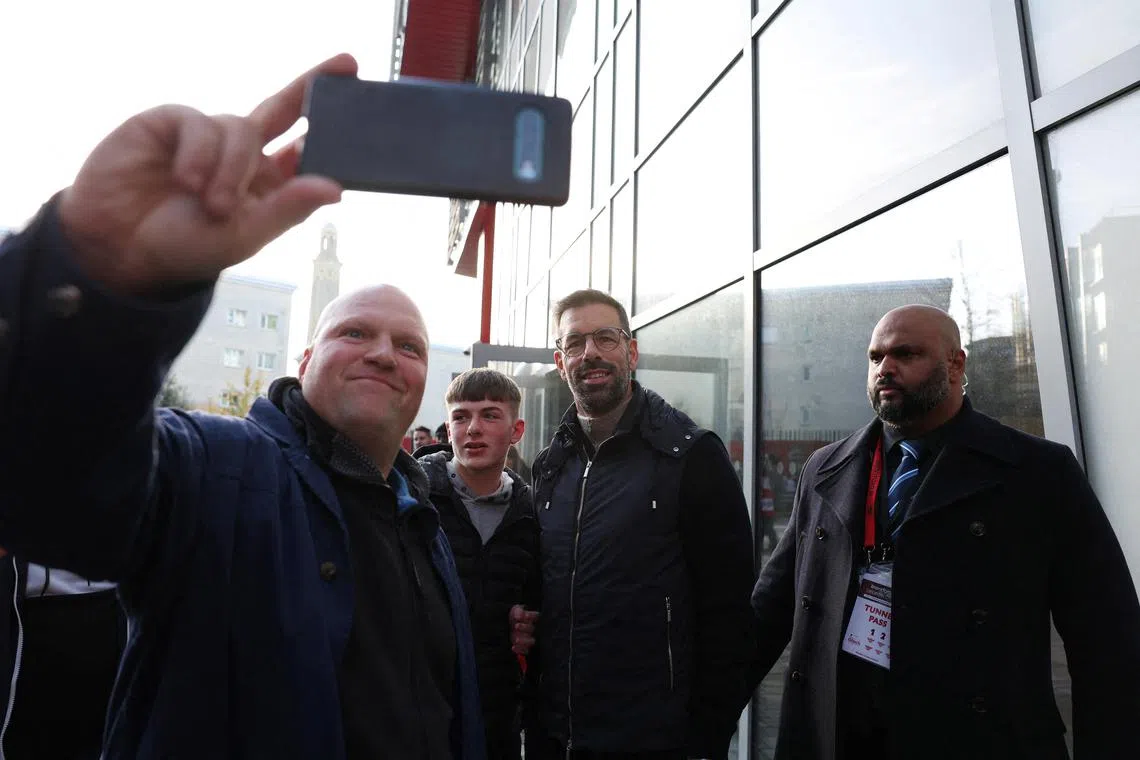 New Leicester City manager Ruud van Nistelrooy poses for a selfie with a fan outside the stadium before the match against Brentford.