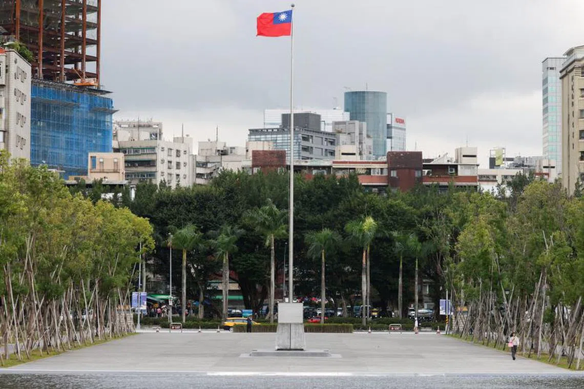 FILE PHOTO: A person walks next to a fluttering Taiwanese flag outside the Sun Yat-Sen Memorial Hall in Taipei, Taiwan November 16, 2023. REUTERS/Carlos Garcia Rawlins/File Photo