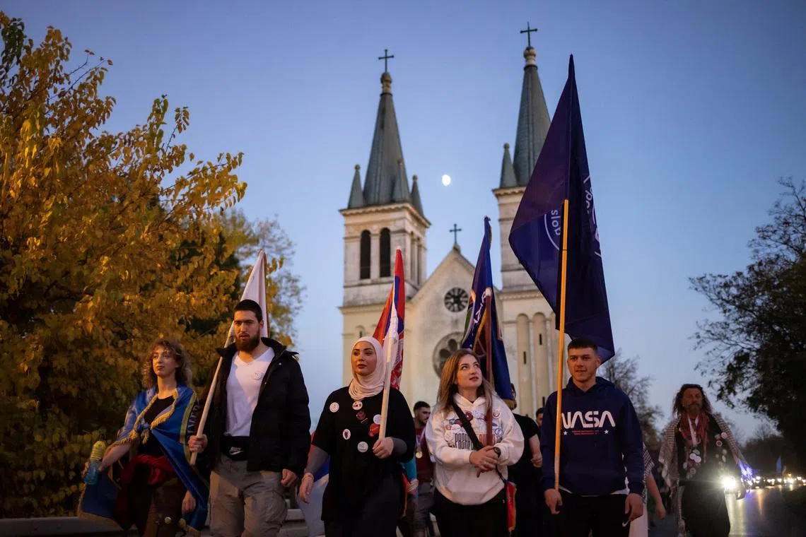 Students from Novi Pazar walk past a church before entering Novi Sad, after completing a walk of more than 400 km from Novi Pazar, in Novi Sad, Serbia, October 31, 2025. A year-long blockade of Novi Pazar University by the students, which had stopped lectures from taking place, ended little over a week ago, after the replacement of the university's rector and the reversal of a ban on 200 students, who had been expelled for their anti-government activism. Their protest outlasted those at most other universities in Serbia, and saw students occupy the buildings even after authorities had cut the heating. REUTERS/Marko Djurica