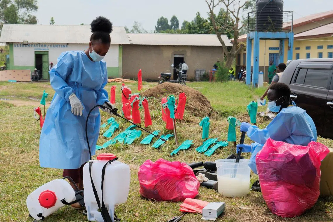 FILE PHOTO: Medical workers dressed in personal protective equipment (PPE) disinfect their equipment at an Ebola treatment centre during a ceremony to present recovery certificates to patients at the Rwambara General Reference Hospital in Bunia, eastern Democratic Republic of Congo, June 16, 2026. REUTERS/Gradel Muyisa Mumbere/File Photo