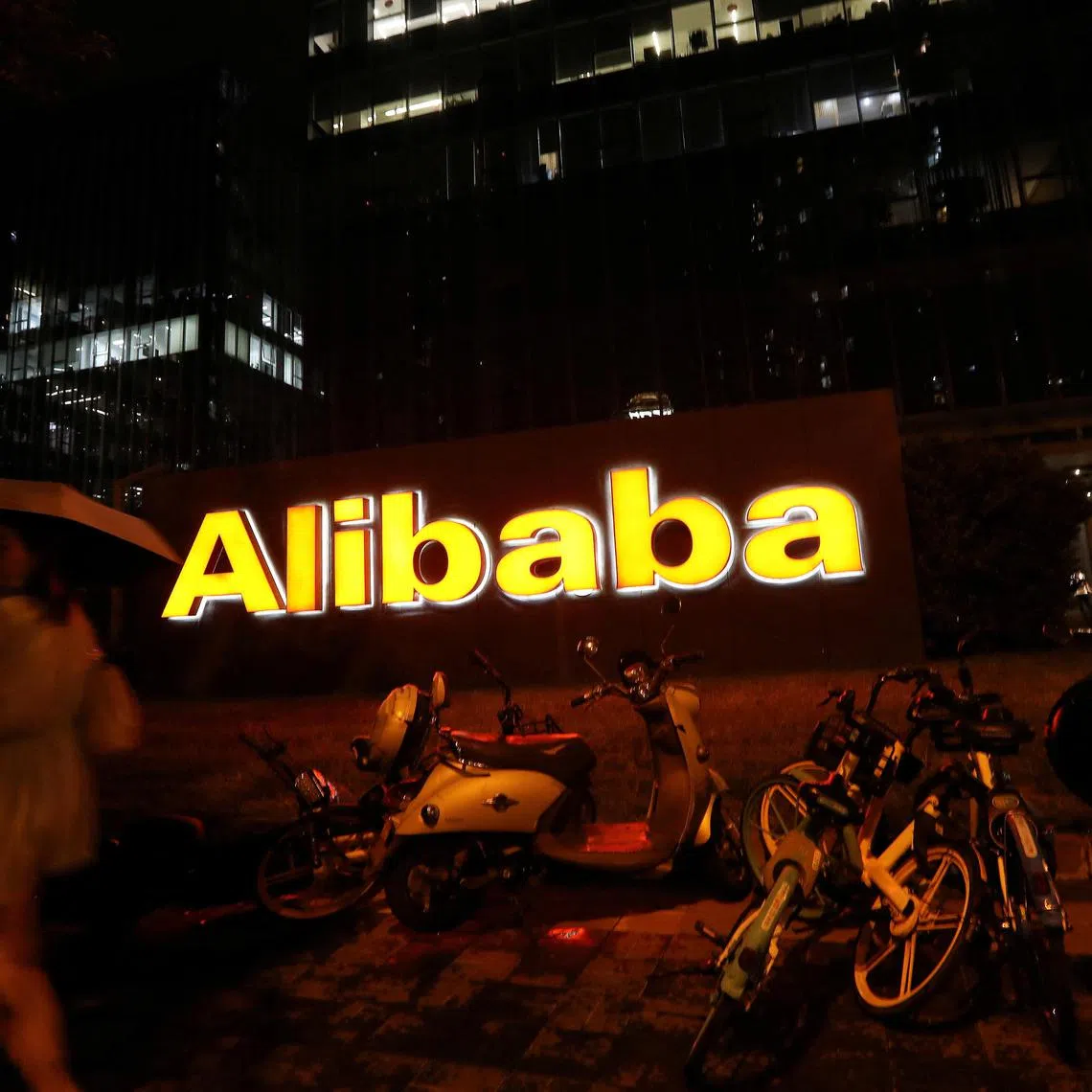 FILE PHOTO: The logo of Alibaba Group is seen lit up at its office building in Beijing, China August 9, 2021. REUTERS/Tingshu Wang/File Photo