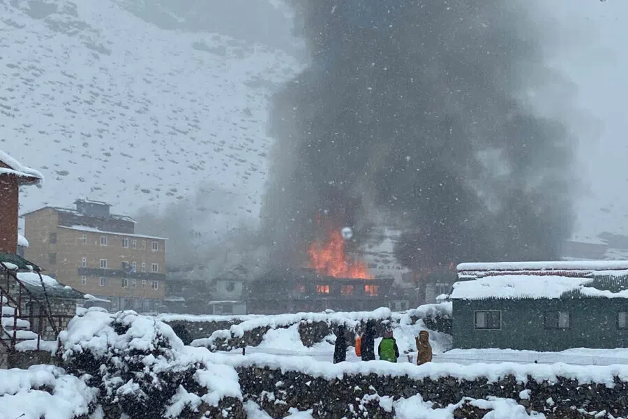 Onlookers watch as a fire guts Hotel Good Luck, which lies along a route leading to the Mount Everest base camp.
