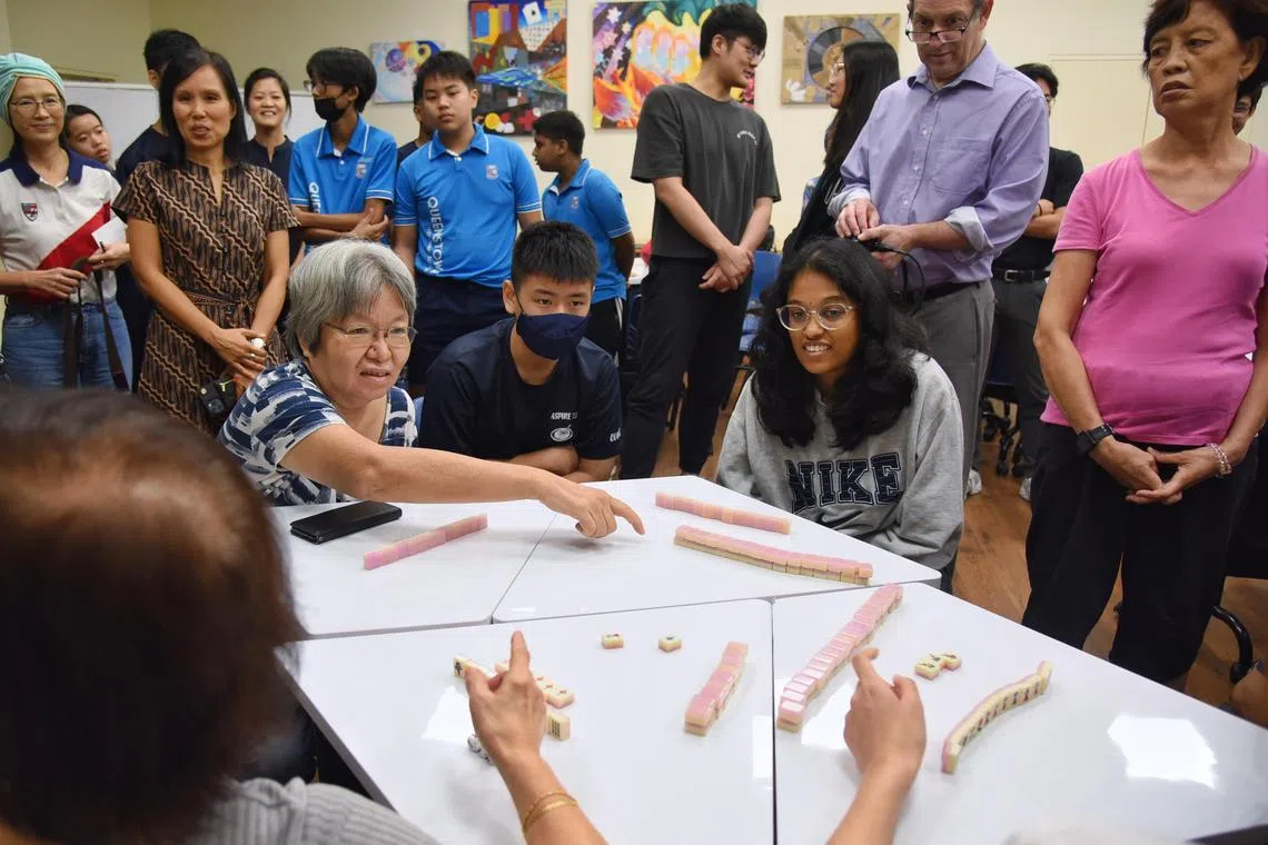 Second-year NUS student R Shalini Sai Kamaladarshini (table, far right), playing mahjong with Ms Angeline Tan (far left), at Queenstown Secondary School on April 5.