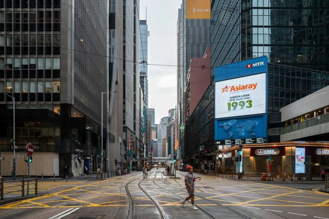 Pedestrians cross an empty street in Central district during Super Typhoon Ragasa in Hong Kong, China, on Tuesday, Sept. 23, 2025. Hong Kong has issued its third-highest storm warning as Super Typhoon Ragasa tracks toward the financial hub with fierce winds, which could potentially be the most damaging storm since Mangkhut in 2018. Photographer: Justin Chin/Bloomberg
