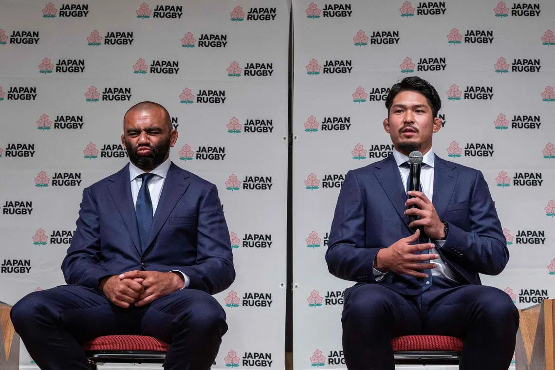 Japan's back row and former skipper Michael Leitch (left) listening as back-row forward and captain Kazuki Himeno speaks during a press conference in Tokyo on Tuesday, after Japan announced the team headed to the 2023 Rugby World Cup in France.