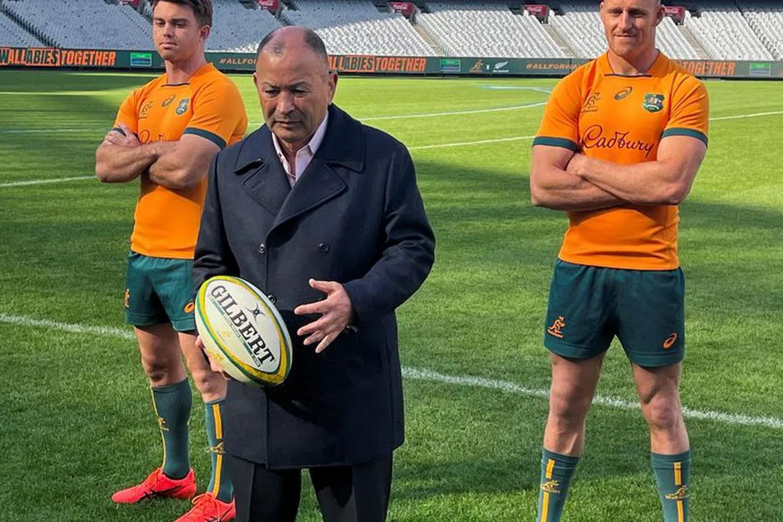 FILE PHOTO-Australia rugby union coach Eddie Jones poses with a ball, flanked by Wallabies players Andrew Kellaway and Reece Hodge at a news conference, at the Melbourne Cricket Ground, in Melbourne, Australia, May 1, 2023. REUTERS/Ian Ransom/File Photo