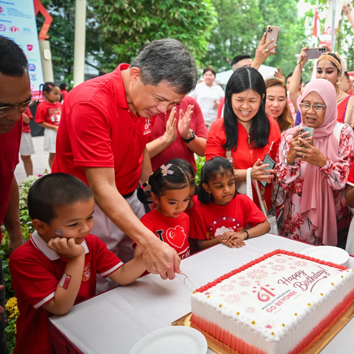 Defence Minister Chan Chun Sing cutting a commemorative cake alongside children and residents at the Buona Vista National Day Observance Ceremony at Block 2 Holland Ave on Aug 9.