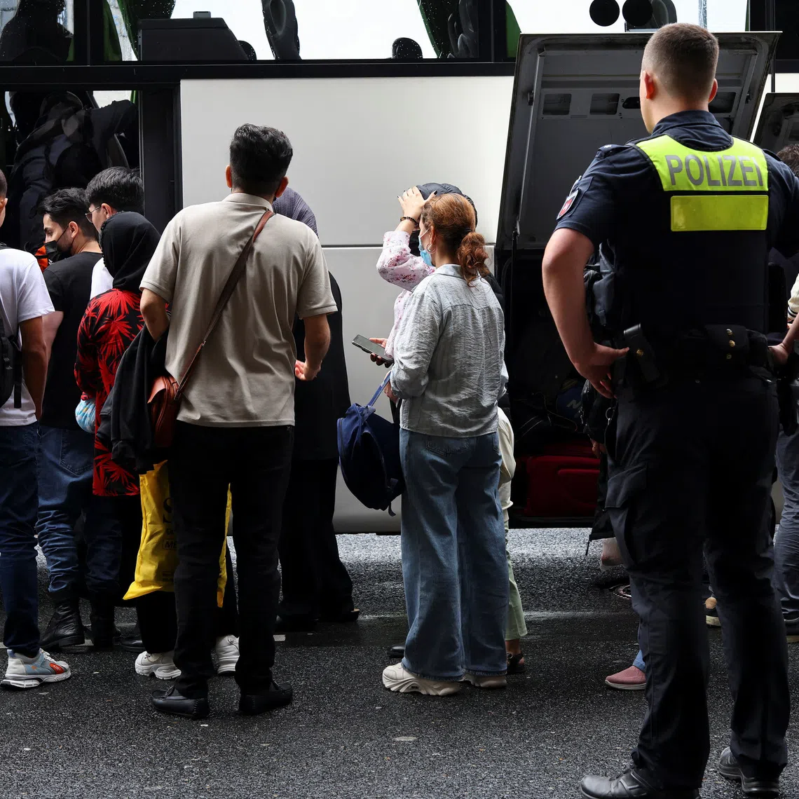 Afghan nationals board a bus as they arrived in Germany from Pakistan at Hannover Airport, after legal and diplomatic pressure pushed Germany to resume a scheme that allows the entry of vulnerable Afghans, in Hannover, Germany, September 1, 2025. REUTERS/Christian Mang