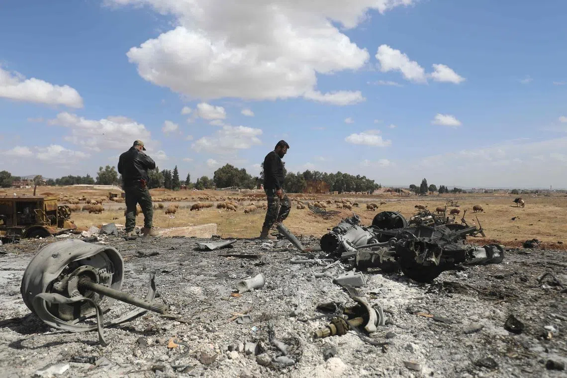 Men checking the scene of an Israeli strike in Syria's southern Hama governorate, on April 3.