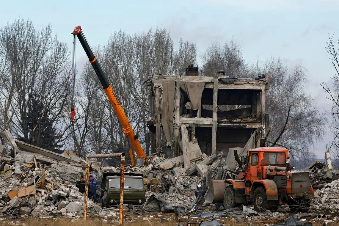 Workers remove debris of a destroyed building purported to be a vocational college used as temporary accommodation for Russian soldiers, dozens of whom were killed in a Ukrainian missile strike as stated previously by Russia's Defence Ministry, in the course of Russia-Ukraine conflict in Makiivka (Makeyevka), Russian-controlled Ukraine, January 4, 2023. REUTERS/Alexander Ermochenko