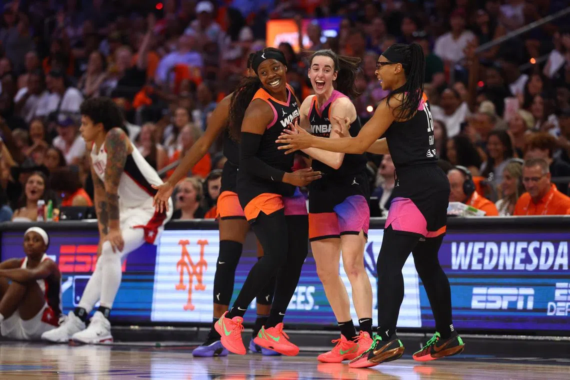 Team WNBA player Arike Ogunbowale celebrates with Caitlin Clark and Allisha Gray after making a three-point shot during the second half against Team USA in the All-Star game on July 20, 2024.