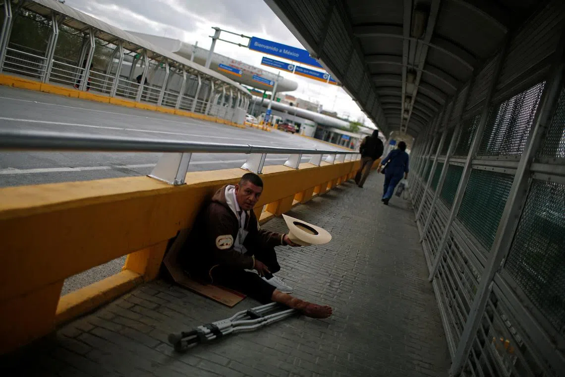FILE PHOTO: A beggar sits at the McAllen-Hidalgo international bridge in Reynosa, Mexico January 11, 2019. REUTERS/Tomas Bravo/File Photo