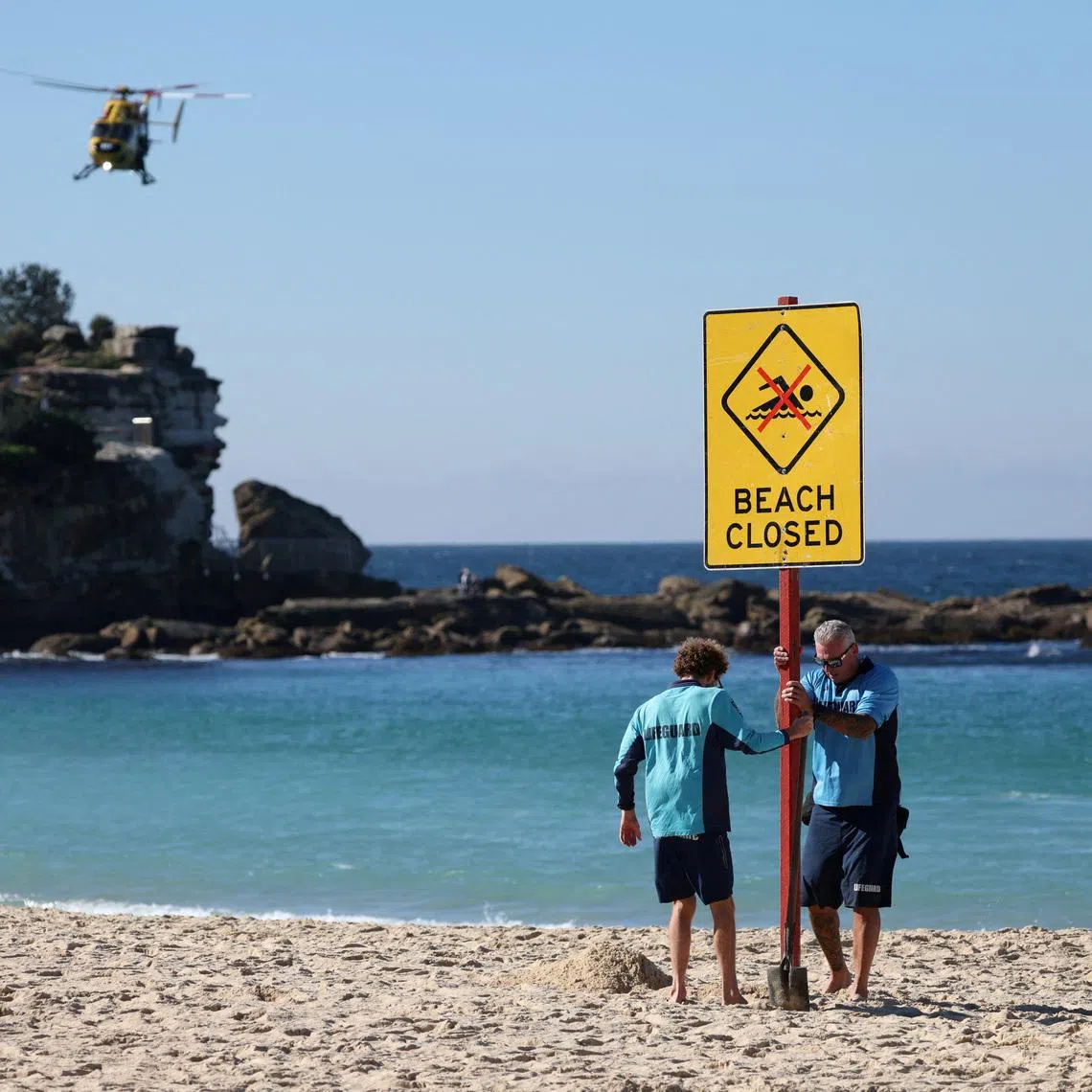 Lifeguards erect a sign that says "Beach Closed" following a shark attack at Coogee Beach in Sydney, Australia, on June 13.