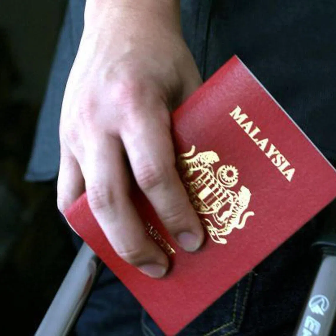 A person holding a Malaysian passport.