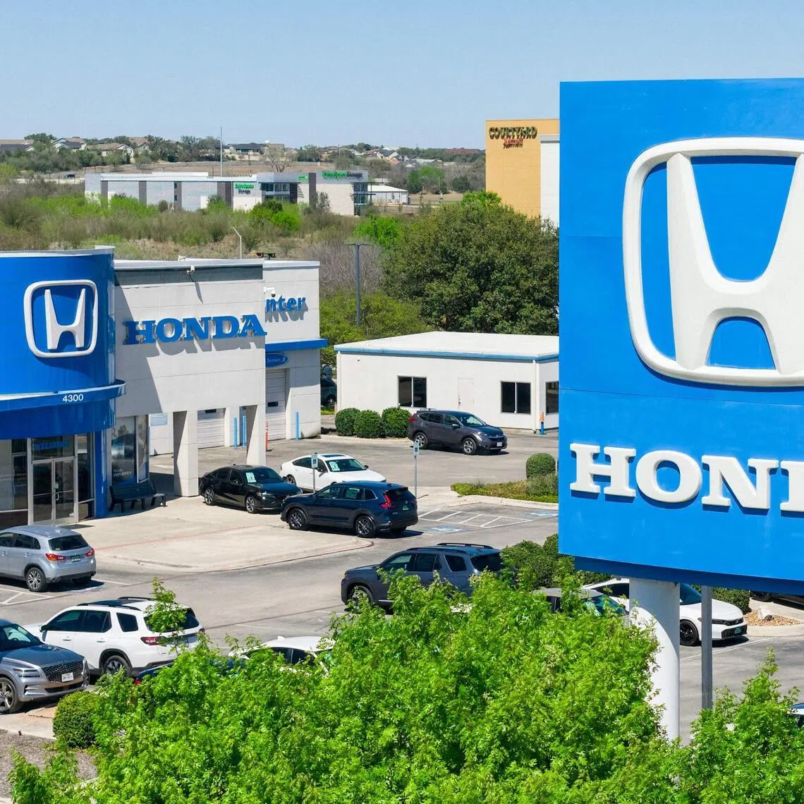 SAN MARCOS, TEXAS - MARCH 12: In an aerial view, the Honda of San Marcos dealership is seen on March 12, 2026 in San Marcos, Texas. Honda Motor expects up to $15.7 billion in expenses and losses as it plans to cancel several EV model launches and development programs in response to a slowdown in North America’s electric vehicle market.   Brandon Bell/Getty Images/AFP (Photo by Brandon Bell / GETTY IMAGES NORTH AMERICA / Getty Images via AFP)