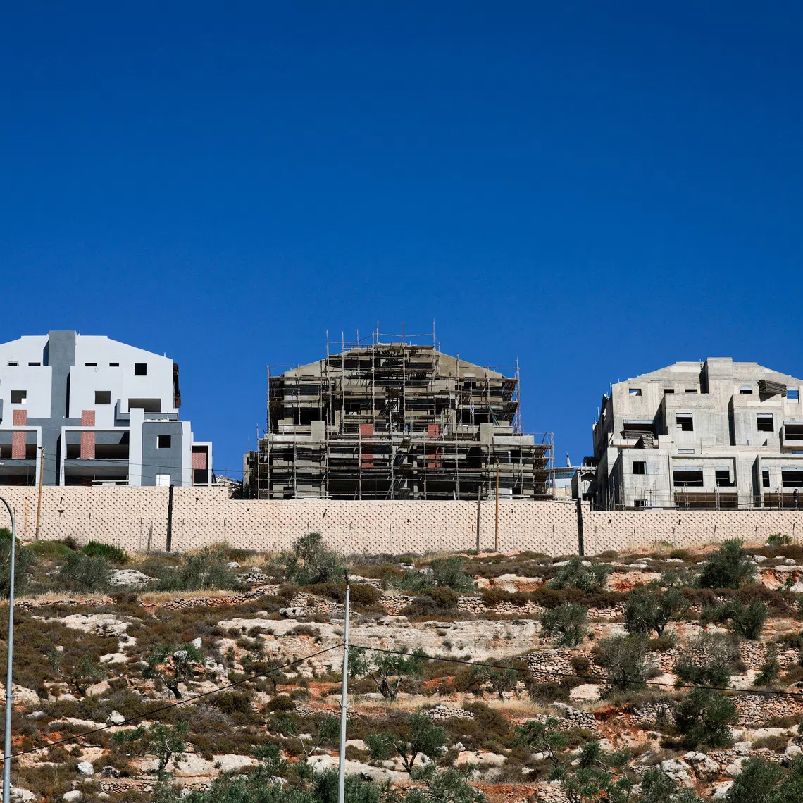 FILE PHOTO: New buildings stand around the Israeli settlement Migdalim near Nablus, in the Israeli-occupied West Bank, May 30, 2025. REUTERS/Ammar Awad/File Photo