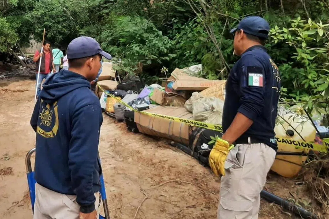 Rescuers work at the accident site, where a bus plummeted into a ravine in Mexico's Oaxaca state.
