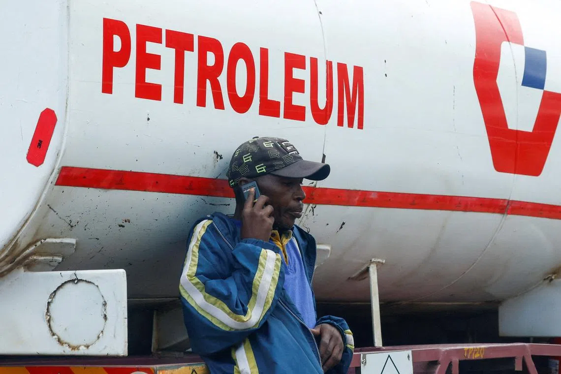 FILE PHOTO: A dealer talks on his mobile phone as fuel tankers queue outside the Kenya Pipeline Company (KPC) depot to re-fuel their commercial supplies, amid the U.S.-Israeli conflict with Iran, in the Industrial Area district of Nairobi, Kenya March 24, 2026. REUTERS/Thomas Mukoya/File Photo