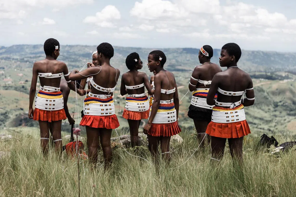 Young maidens of the Nazareth Baptist Church, from the Ekuphakameni group, also known as the Shembe Church, prepare to take part in a cultural dance on the Nhlangakazi Holy Mountain in Ndwedwe 85 kilometres north of Durban, on January 8, 2023. - The devotees climb the mountain as part of their annual 10 day pilgrimage. The church was founded in 1913 and is one of the largest African traditionalist church in Africa. They walk up to 68kms barefoot praying, worshipping, singing, dancing and camping on their four weeks stay at the mountain. The Shembe Church is the oldest independent indigenous Church in Southern Africa. (Photo by RAJESH JANTILAL / AFP)