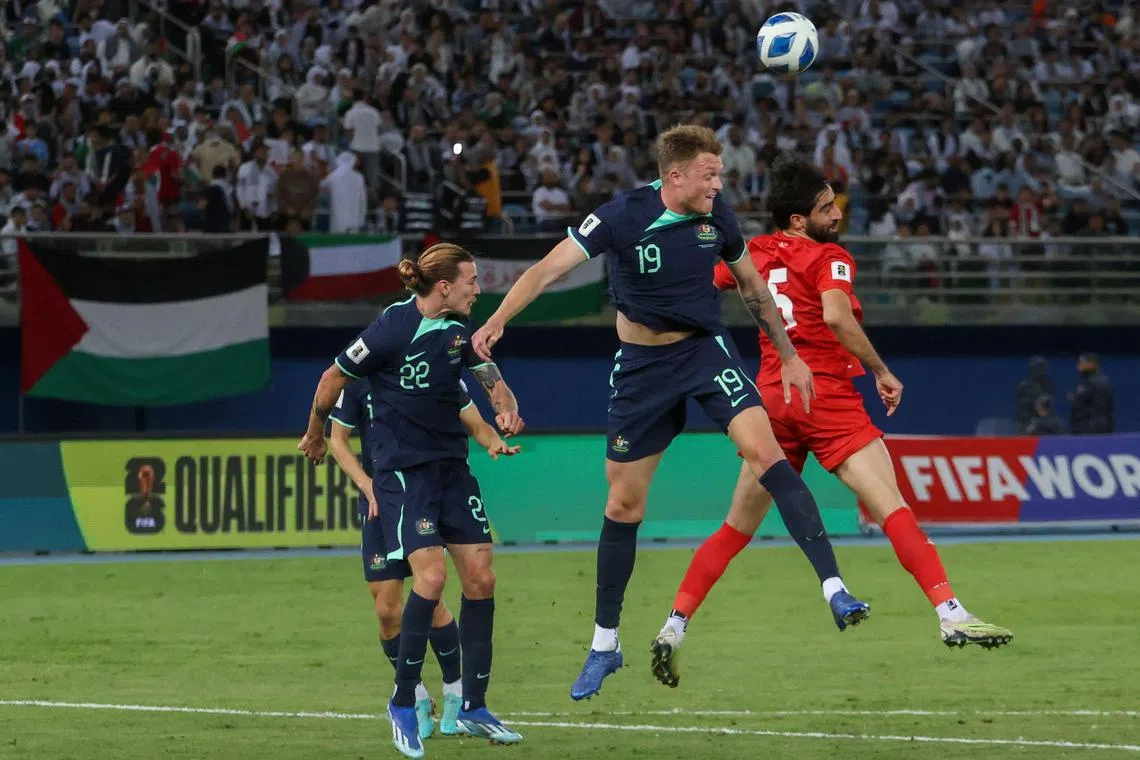 Australia defender Harry Souttar jumps for the ball with Palestine defender Mohammed Saleh during a World Cup qualifier in November.