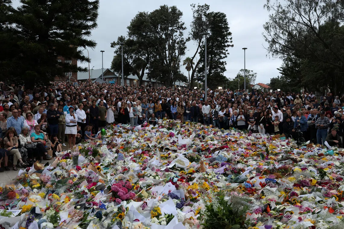 People lay flowers and pay tributes at Bondi Beach to honour the victims of a mass shooting that targeted a Jewish Holiday celebration on Sunday at Bondi Beach, in Sydney, Australia, December 16, 2025. REUTERS/Hollie Adams