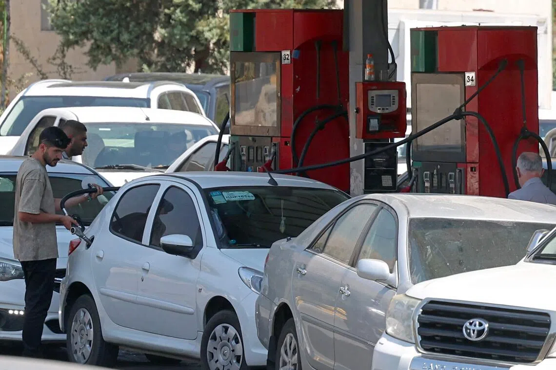 Drivers queue at a petrol station to refuel in Tehran.