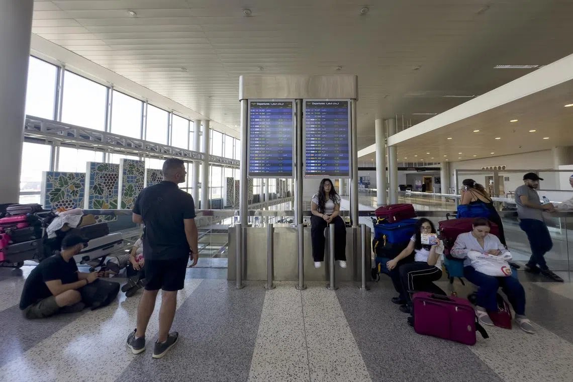 epa11506145 Passengers wait near their luggage after their flights were delayed or canceled at Rafik Hariri International Airport, in Beirut, Lebanon, 29 July 2024. Several flights to and from Beirut airport were canceled or delayed on 29 July as tensions escalated between Israel and Hezbollah. Lufthansa, Swiss and Eurowings of the Lufthansa Group announced suspension of their flights from and to Beirut until 05 August, Air France announced a two-day suspension of flights between Paris and Beirut, while the Lebanese Middle East Airlines (Air Liban) announced delays of five out of the thirty-five scheduled flights due to the 'distribution of insurance risks' for aircraft between Lebanon and other destinations.  EPA-EFE/WAEL HAMZEH