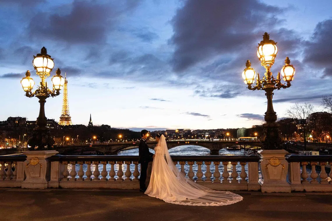 A married couple posing on the Alexander III Bridge on the river Seine in central Paris in March. Doctors in the United States say they are increasingly seeing requests for bridal surgery treatments before the big day. 