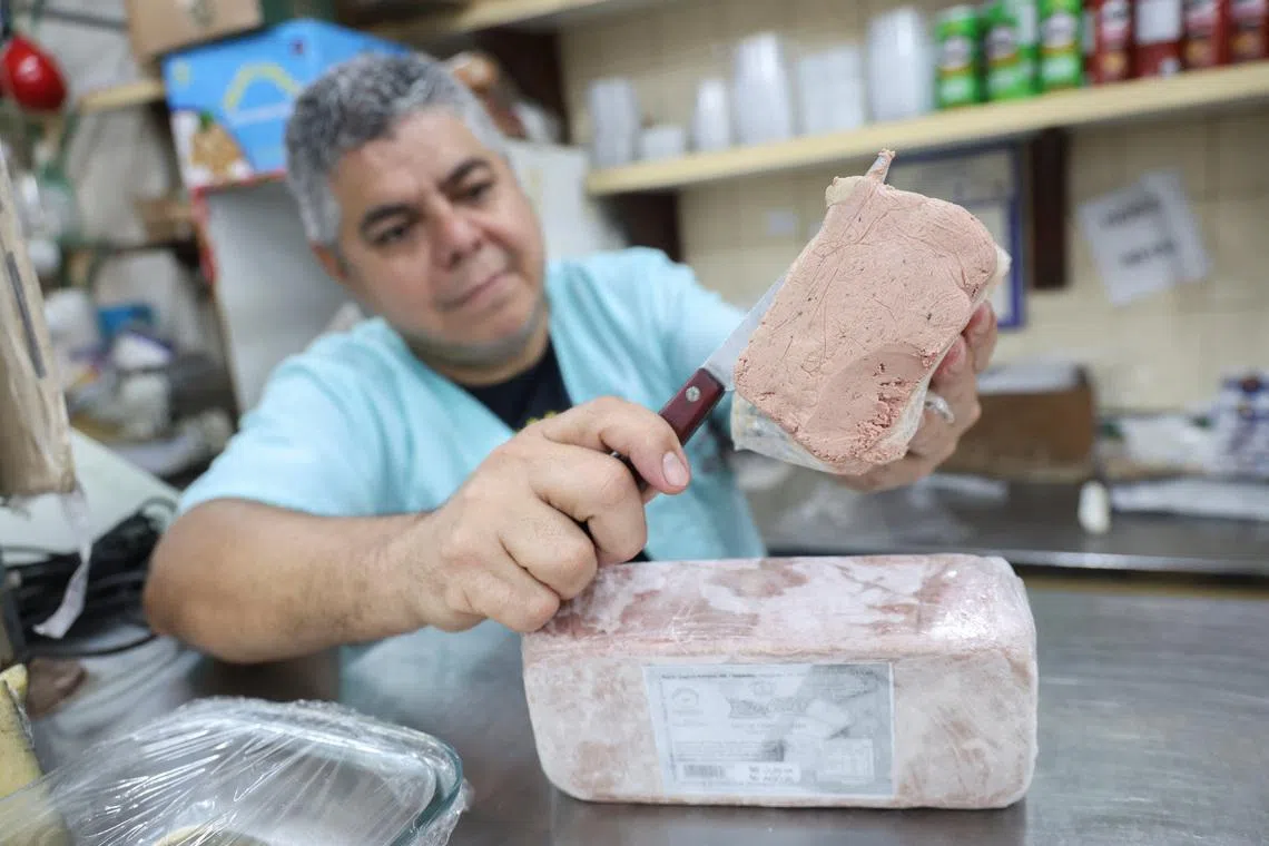 A vendor slices a pate of foie gras at a shop in Rio de Janeiro, Brazil, July 24, 2026, after President Luiz Inacio Lula da Silva signed a law banning the production and sale of the French delicacy in the South American country, citing animal cruelty concerns. REUTERS/Aline Massuca