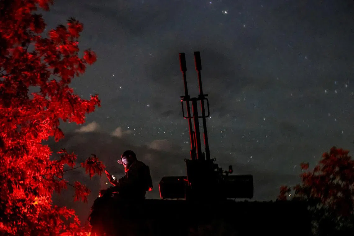 FILE PHOTO: A Ukrainian serviceman from an anti-drone mobile air defence unit uses his mobile device near a ZU-23-2 anti aircraft cannon as he waits for Russian kamikaze drones, amid Russia's attack on Ukraine, in Kherson region, Ukraine June 11, 2024. REUTERS/Ivan Antypenko/File Photo