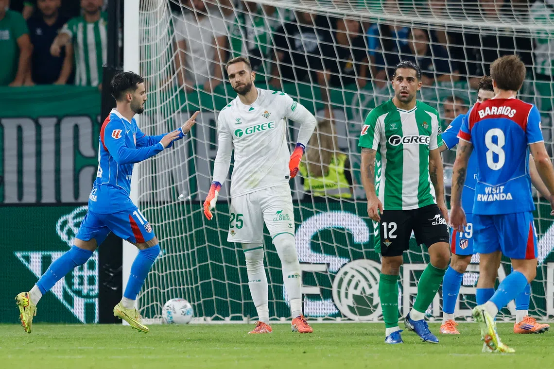 Soccer Football - LaLiga - Real Betis v Atletico Madrid - Estadio de La Cartuja, Seville, Spain - October 27, 2025 Atletico Madrid's Alex Baena celebrates scoring their second goal as Real Betis' Pau Lopez looks dejected REUTERS/Marcelo Del Pozo