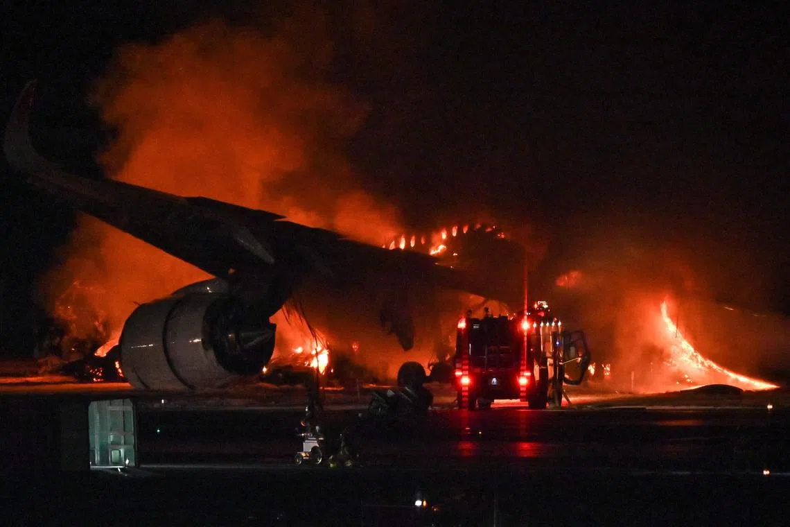 A Japan Airlines passenger plane is seen on fire on the tarmac at Tokyo International Airport at Haneda on Jan 2 after apparently colliding with a coast guard aircraft.