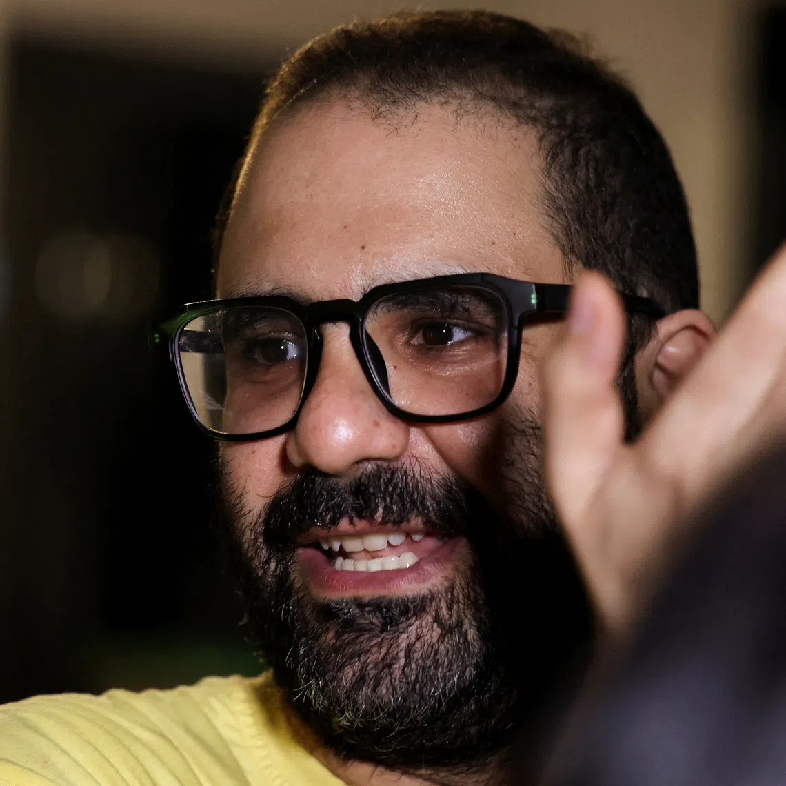 Prominent British-Egyptian activist Alaa Abd el-Fattah, who was released from prison after Egyptian President Abdel Fattah al-Sisi issued a presidential pardon for him, gestures as family and friends gather at home in Giza, Egypt, September 23, 2025. REUTERS/Mohamed Abd El Ghany