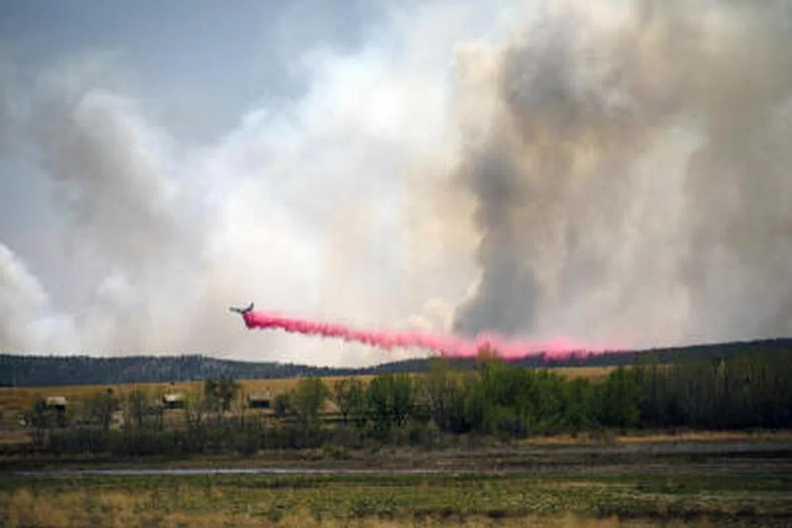 A plane drops fire retardant in an effort to fight a wildfire.