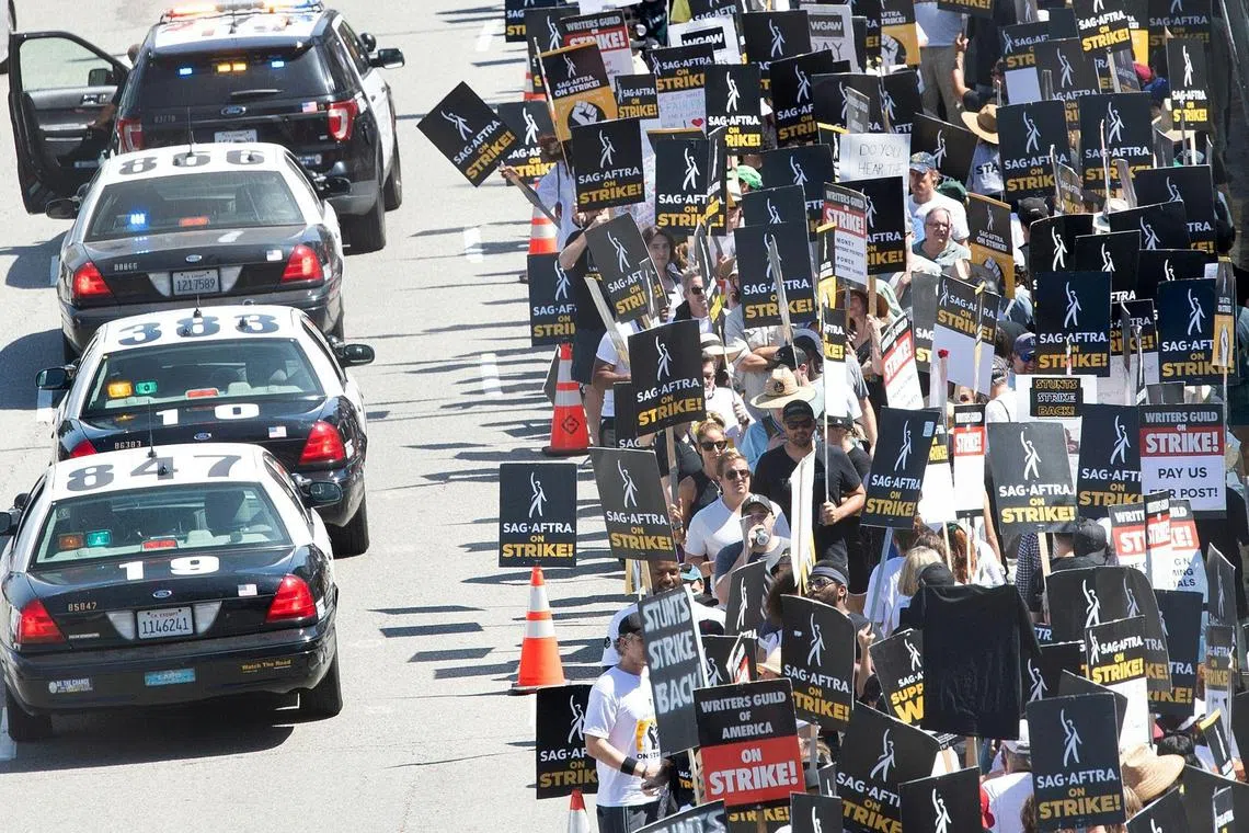 Members of the Writers Guild of America and the Screen Actors Guild walk the picket line outside of Universal Studios in Burbank, California.