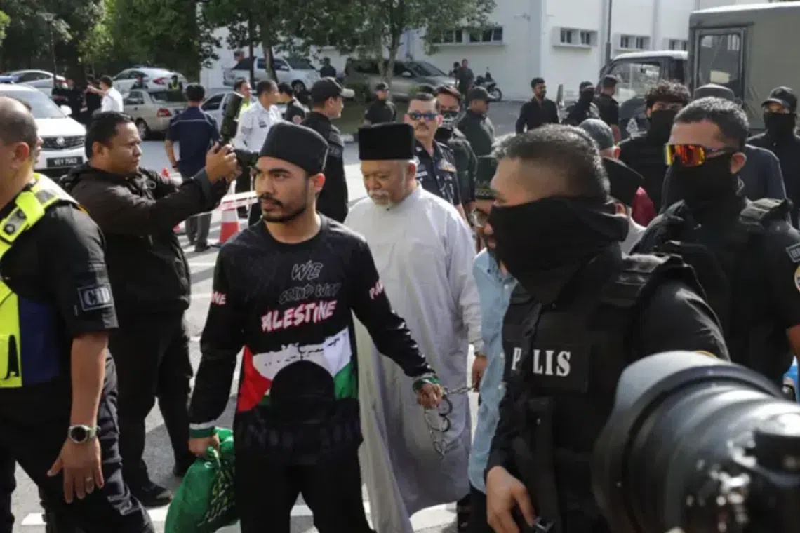 GISB Holdings Sdn Bhd CEO Nasiruddin Mohd Ali (in white) were among 22 individuals charged for being members of an organised criminal group.