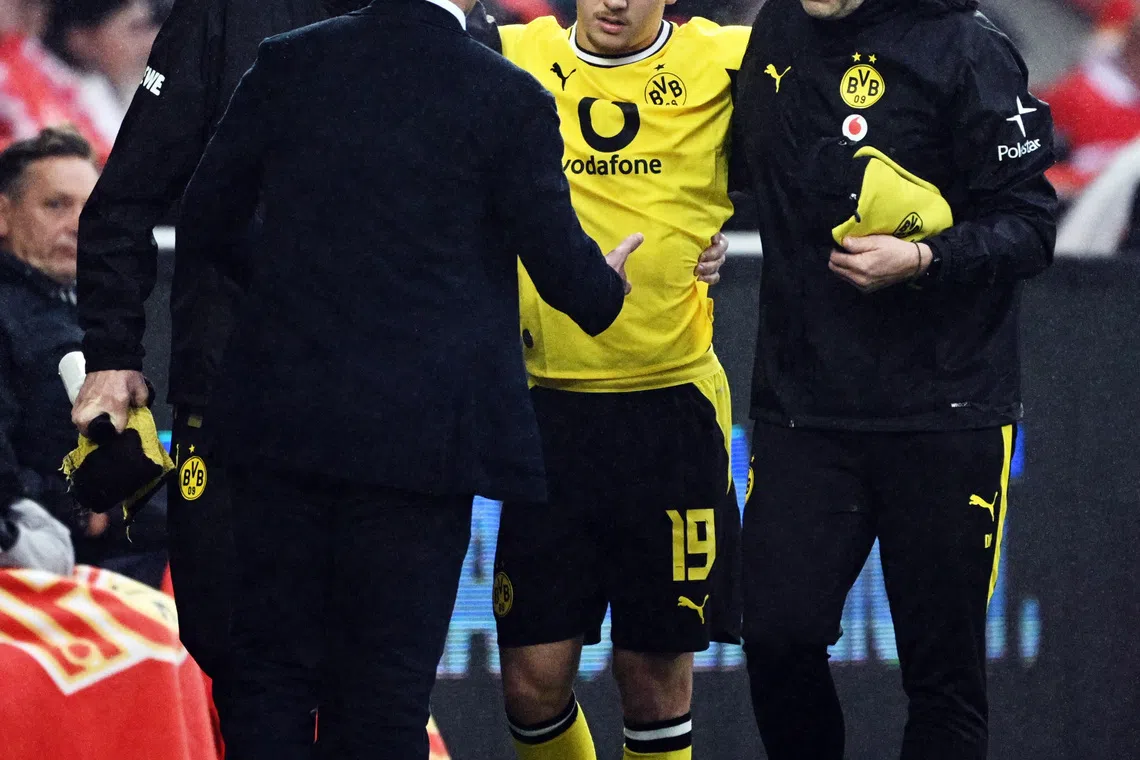 Soccer Football - Bundesliga - 1. FC Union Berlin v Borussia Dortmund - Stadion An der Alten Forsterei, Berlin, Germany - October 17, 2026 1. FC Union Berlin coach Mauro Lustrinelli consoles Borussia Dortmund's Konstantinos Karetsas as he is helped after being substituted after sustaining an injury REUTERS/Annegret Hilse