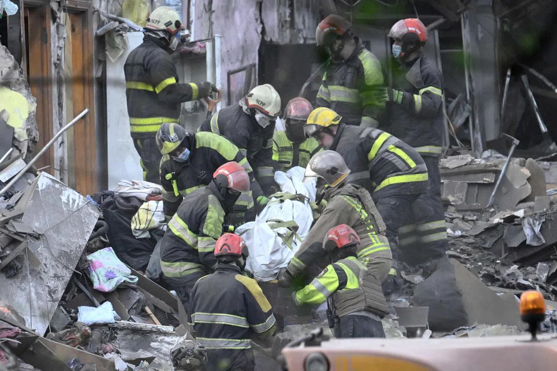 Ukrainian rescuers carrying the body of a victim at the site of a Russian missile strike, in Kyiv, on April 24.