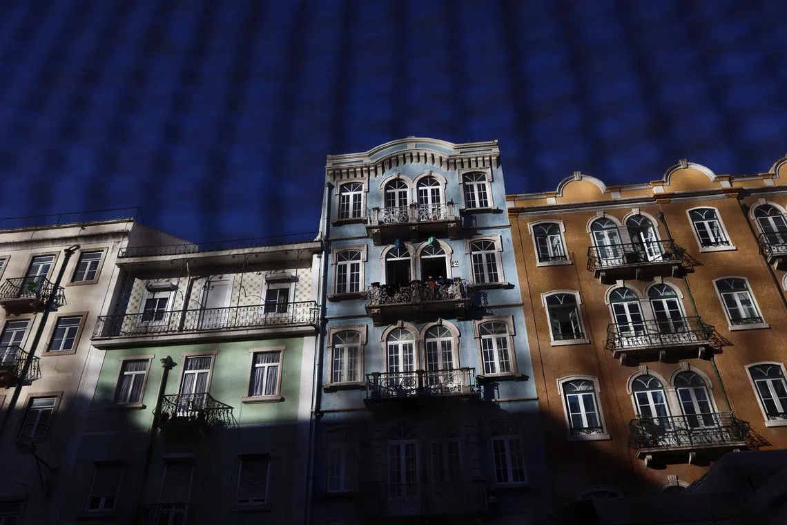 FILE PHOTO: Residential buildings are seen through a fence in Lisbon, Portugal, March 15, 2023. REUTERS/Pedro Nunes/File Photo