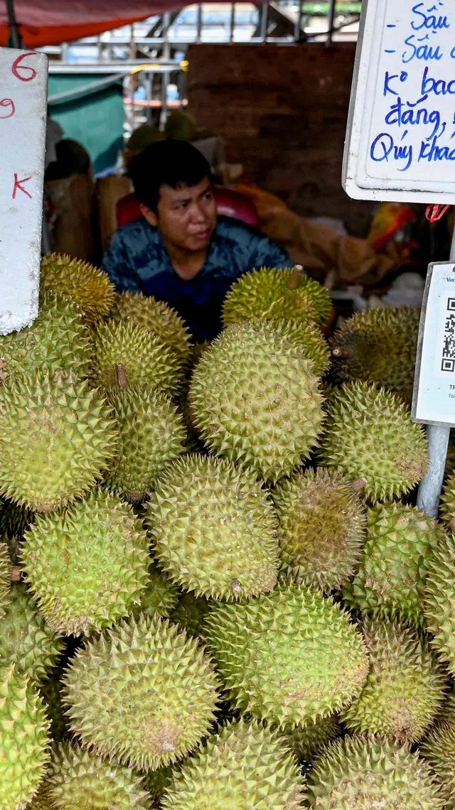 A man waits for customers at a durian stall at a market in Hanoi on July 17, 2026. (Photo by Nhac NGUYEN / AFP)