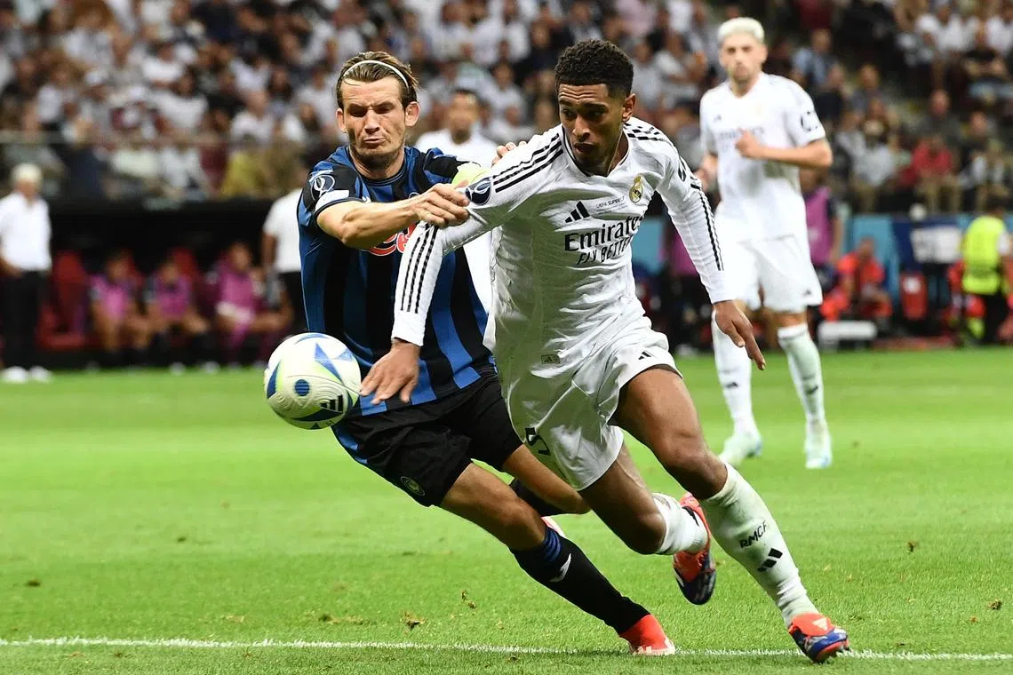 FILE PHOTO: Soccer Football - Super Cup - Real Madrid v Atalanta - National Stadium, Warsaw, Poland - August 14, 2024 Real Madrid's Jude Bellingham in action with Atalanta's Marten de Roon REUTERS/Jennifer Lorenzini