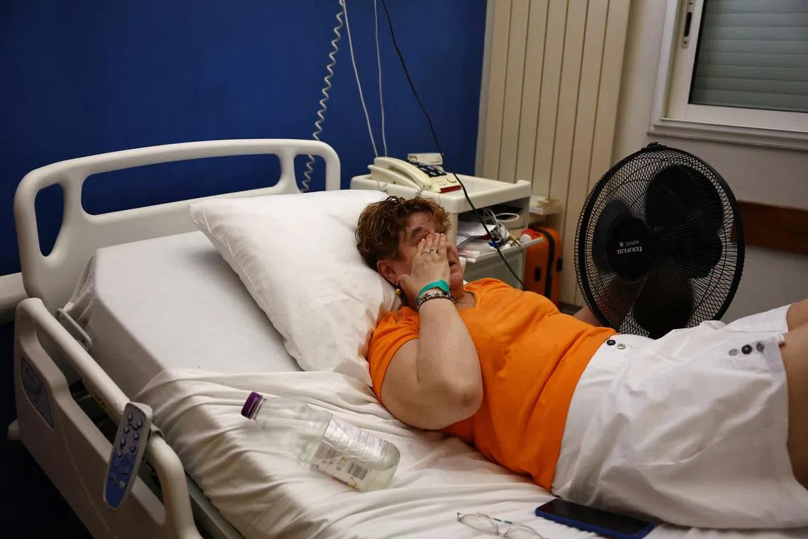 A patient lying in a hospital bed cools off with an electric fan at the Manhes Private Hospital in Fleury-Merogis near Paris during a heatwave affecting a majority of the country, France, June 25, 2026. REUTERS/Abdul Saboor